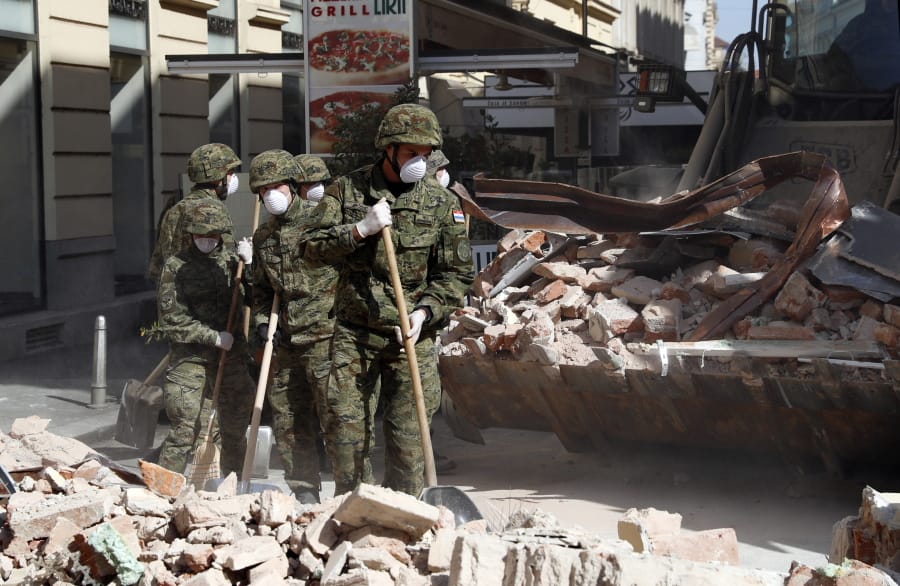 Croatian soldiers clear debris from the street after an earthquake in Zagreb, Croatia, Sunday, March 22, 2020. A strong earthquake shook Croatia and its capital on Sunday, causing widespread damage and panic.