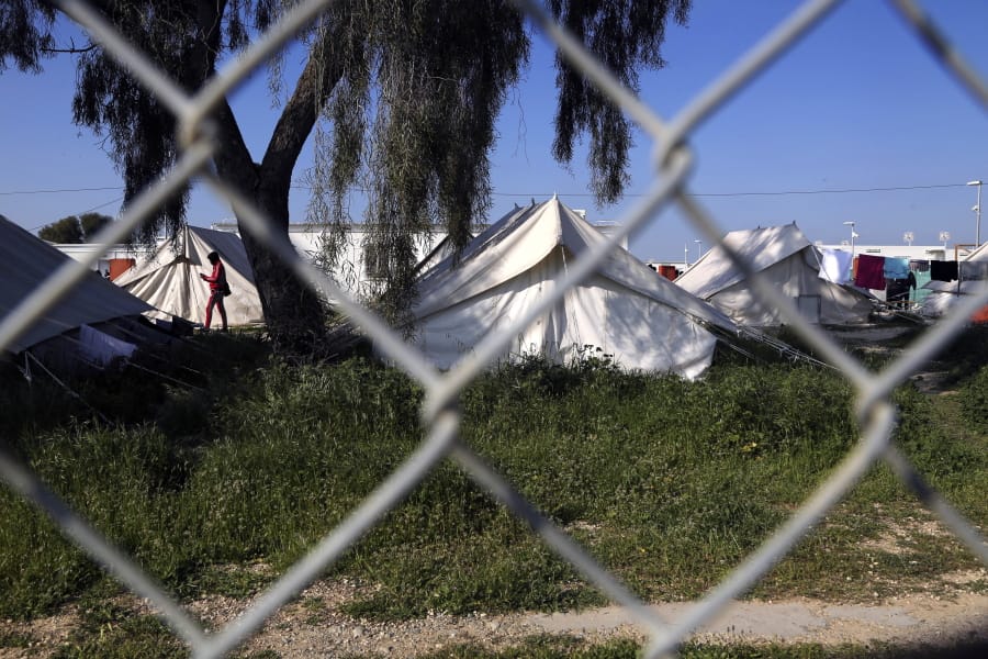 A migrant walks by the tents inside a refugee camp in Kokkinotrimithia outside of Nicosia, Cyprus, Tuesday, March 3, 2020. The government of ethnically divided Cyprus is ramping up measures to stem migrant inflows amid fears of a surge of new arrivals following Turkey&#039;s decision to open its borders to those seeking to enter Europe illegally.