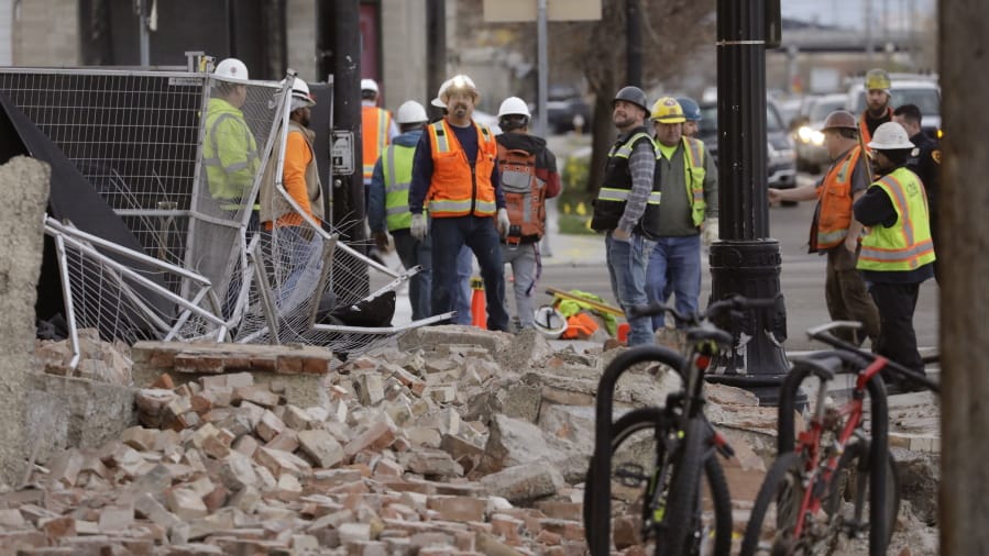 Construction workers looks at the rubble from a building after an earthquake Wednesday, March 18, 2020, in Salt Lake City.  A 5.7-magnitude earthquake has shaken the city and many of its suburbs. The quake sent panicked residents running to the streets, knocked out power to tens of thousands of homes and closed the city&#039;s airport and its light rail system.
