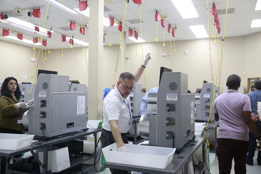A workers raises his hand for more mail in ballots at the Broward County Supervisor Of Elections Office during the Florida Primary elections at the Broward County Supervisor Of Elections Office Tuesday, March 17, 2020, in Lauderhill, Fla.