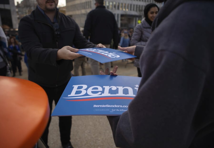 Volunteers hand out signs at a rally for Bernie Sanders at Calder Plaza in Grand Rapids, Michigan on Sunday, March 8, 2020.