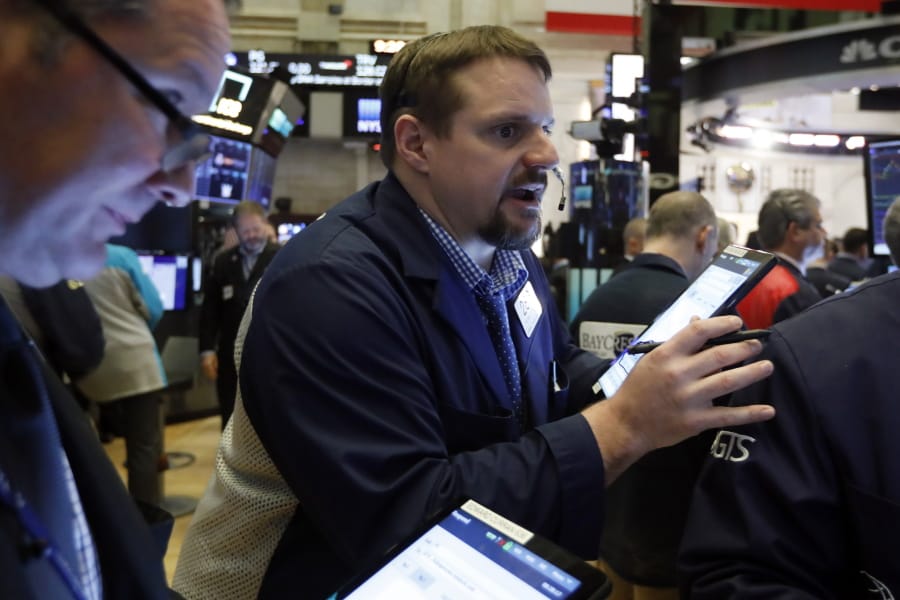 Trader Michael Milano, center, works on the floor of the New York Stock Exchange, Friday, March 6, 2020. Stocks are opening sharply lower on Wall Street and bond yields are sinking to more record lows as investors fear that economic damage from the spreading coronavirus outbreak will be longer than previously thought.