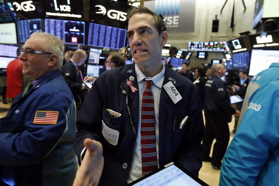 Trader Gregory Rowe, center, works on the floor of the New York Stock Exchange, Thursday, March 5, 2020.  Stocks are opening sharply lower on Wall Street, erasing 2% from major indexes, a day after surging 4% as the mood swings back to fear about the effects of a fast-spreading virus.