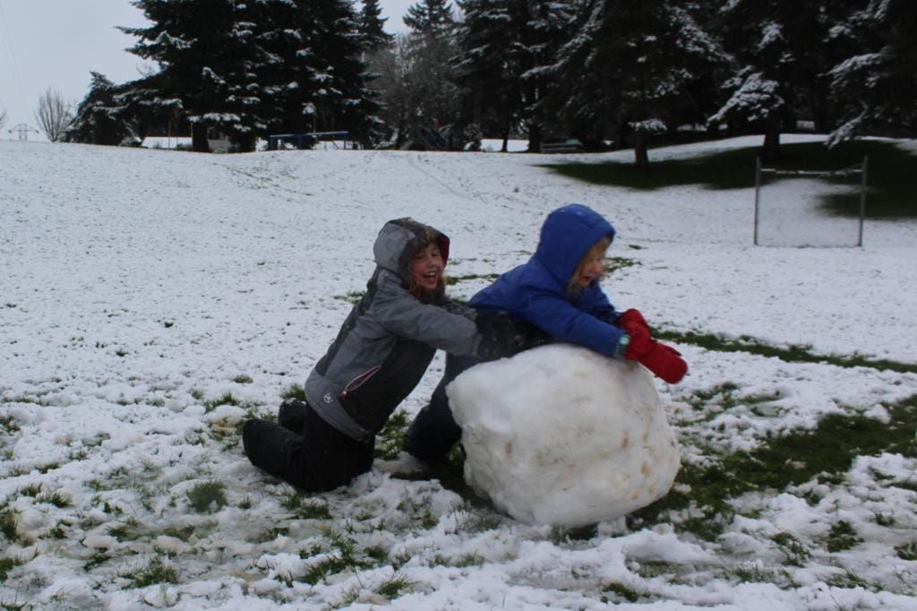 Cady Mae Yurkewycz, 8, left, and her 5-year-old sister Mary Lou take advantage of the March 14 morning snowfall at Franklin Park in Vancouver.