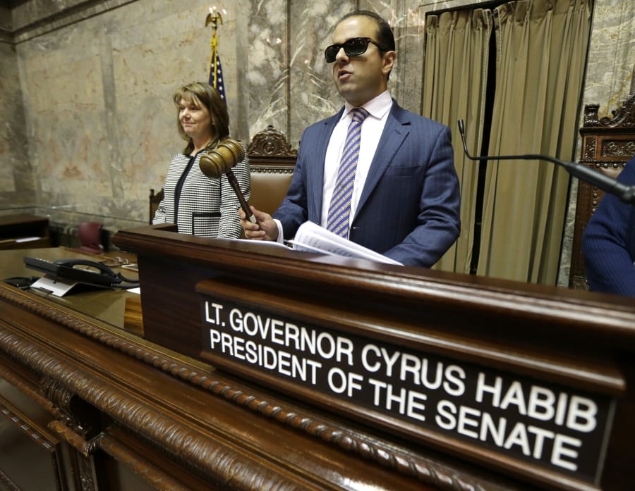 FILE - In this Jan. 5, 2017 file photo, Washington Lt. Gov. Cyrus Habib, right, who is blind, holds the gavel as he stands at the Senate chamber dais next to Senate Counsel Jeannie Gorrell, left,  at the Capitol in Olympia, Wash. Habib announced on Thursday, March 19, 2020, that he is not running for re-election and will join the Jesuit order of the Catholic Church as he starts the process of becoming a priest. (AP Photo/Ted S. Warren, File) (Ted S.