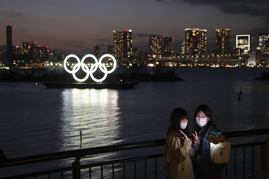 Two women take a selfie with the Olympic rings in the background in the Odaiba section of Tokyo, Thursday, March 12, 2020.  Doping testers around the sporting world are trying to avoid infecting themselves or athletes during the global virus outbreak, and that&#039;s not easy when collecting samples means getting very close to sports stars. (AP Photo/Jae C.