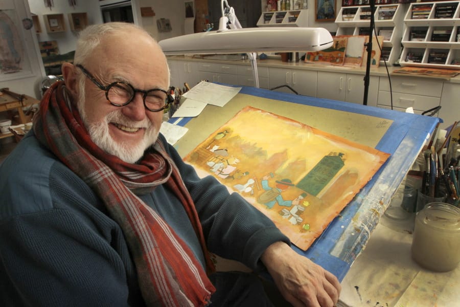 In this photo taken Sunday Dec. 1, 2013, Tomie dePaola poses with his artwork in his studio in New London, N.H. The beloved children&#039;s author and illustrator has died at the age of 85. DePaola delighted generations with tales of Strega Nona, the kindly and helpful old witch in Italy. His literary agent says dePaola died Monday from surgery complications after taking a bad fall last week.