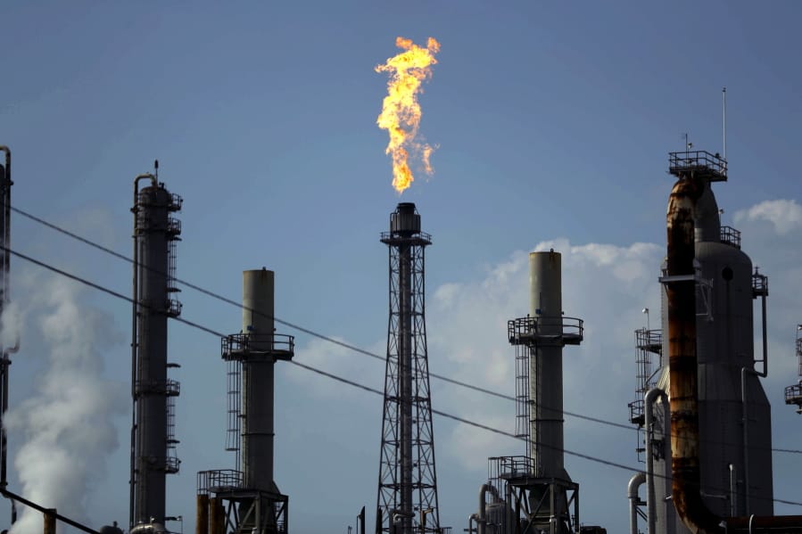 FILE - In this Thursday, Aug. 31, 2017, file photo, a flame burns at the Shell Deer Park oil refinery in Deer Park, Texas. Oil prices are plunging Sunday, March 8, 2020, amid worries that an OPEC dispute will lead a virus-weakened economy to be awash in an oversupply of crude.