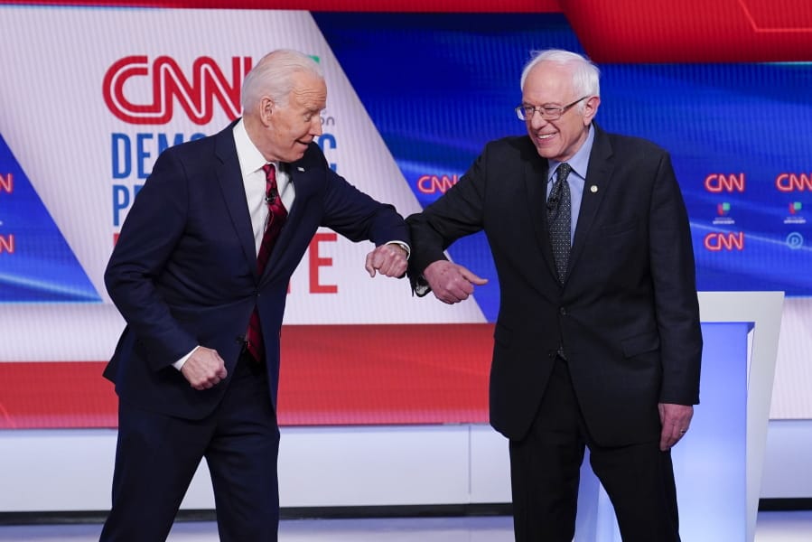 Former Vice President Joe Biden, left, and Sen. Bernie Sanders, I-Vt., right, greet one another before they participate in a Democratic presidential primary debate at CNN Studios in Washington, Sunday, March 15, 2020.