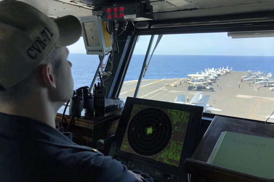 A U.S. Navy crewman monitors the deck of the U.S. aircraft carrier Theodore Roosevelt near the South China Sea in April 2018.