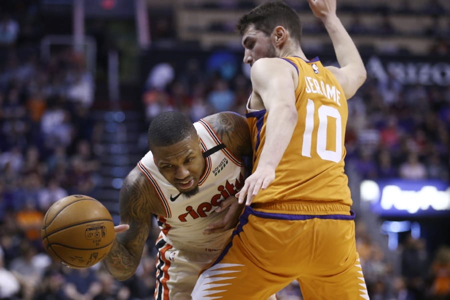 Portland Trail Blazers guard Damian Lillard, left, is fouled as he tries to dribble past Phoenix Suns guard Ty Jerome (10) during the first half of an NBA basketball game Friday, March 6, 2020, in Phoenix. (AP Photo/Ross D.