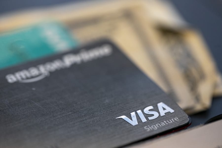 FILE This Aug. 11, 2019 file photo shows a Visa logo on a credit card in New Orleans.  A recent NerdWallet survey found that about a third of Americans plan to travel for spring break but only a third plan to use a credit card for some or all of these costs. That means plenty of spring breakers are missing out on points they could earn charging those expenses to a travel credit card. In addition to earning points, using a travel credit card can provide valuable trip protections and perks.