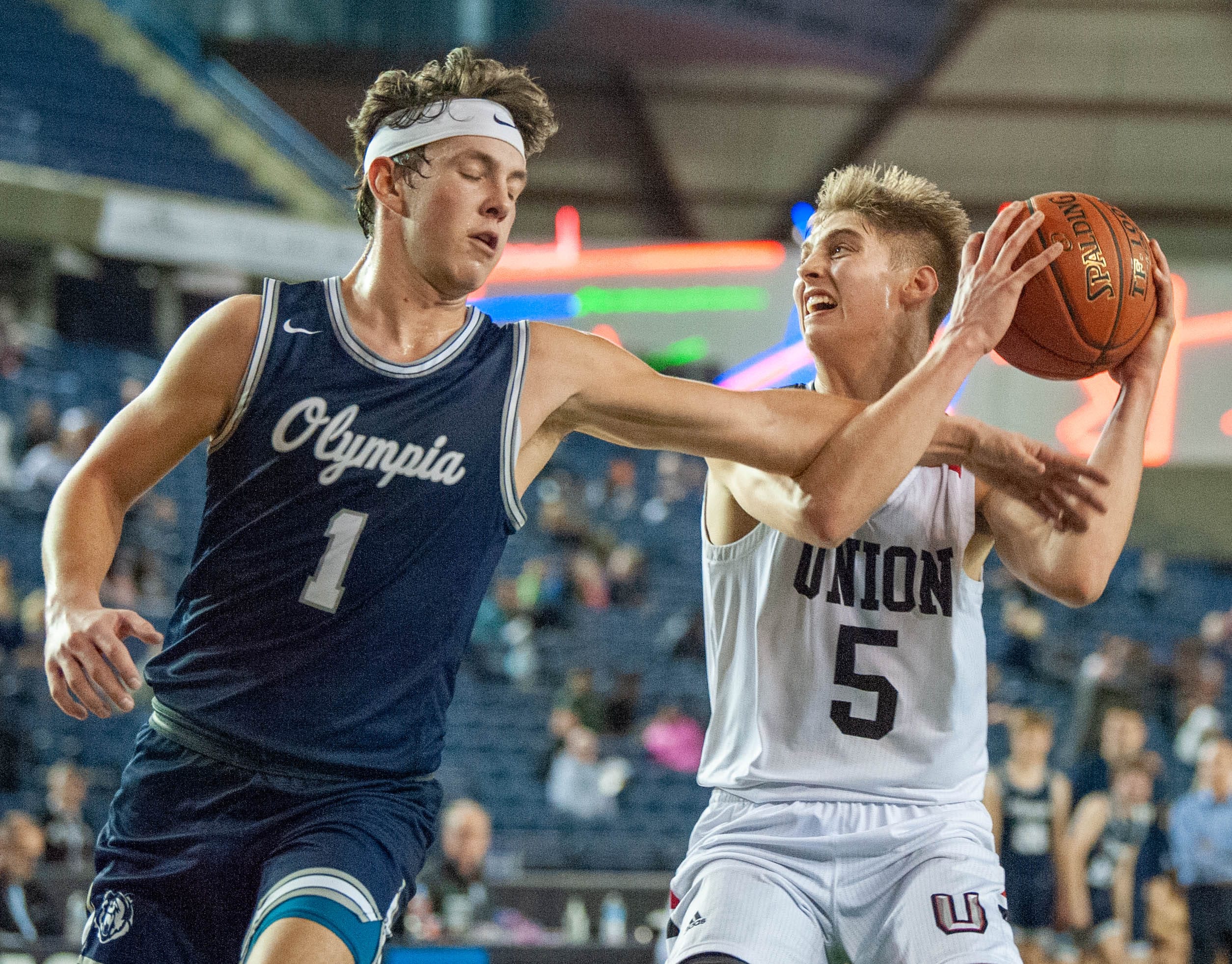 Olympia's Ethan Gahm fouls Union's Tanner Toolson on a fastbreak in a 4A State quarterfinal on Thursday at the Tacoma Dome.