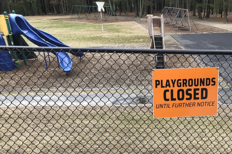FILE - This Friday, March 20, 2020 file photo shows a closed sign near an entrance to a playground at an el ementary school in Walpole, Mass., amid the COVID-19 coronavirus outbreak. Child welfare agencies in the U.S. have a difficult mission in the best of times, and now they&#039;re scrambling to confront new challenges during the coronavirus outbreak.