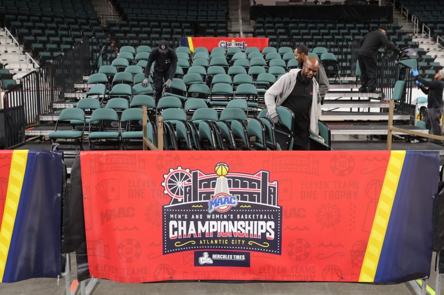 Workers dismantle seating after the men&#039;s and women&#039;s NCAA college basketball games at the Metro Atlantic Athletic Conference tournament were canceled, Thursday March 12, 2020, due to coronavirus concerns.