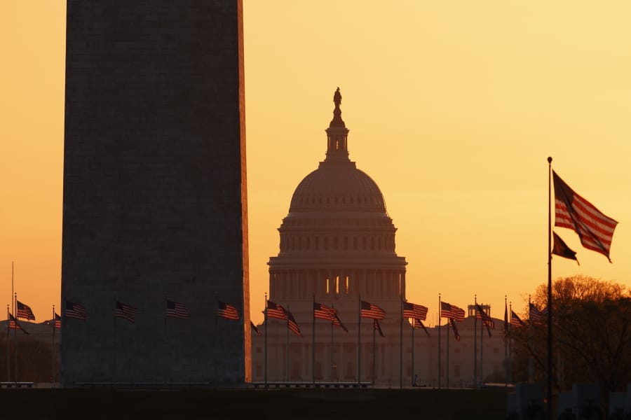 The Washington Monument and the U.S. Capitol are seen in Washington, at sunrise Wednesday, March 18, 2020. The White House has sent Congress an emergency $46 billion spending request for coronavirus-related funding this year.