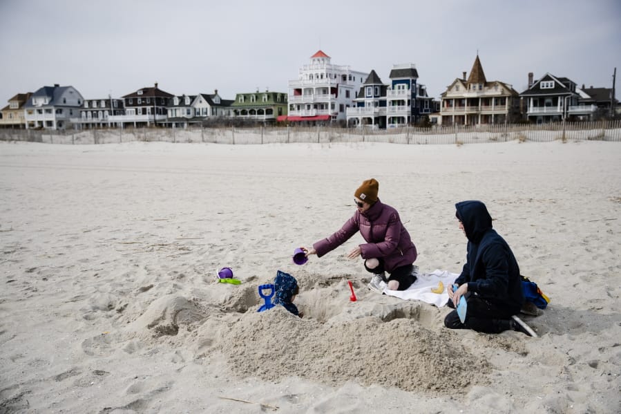 Matt and Anna Mason play with their son, Oliver, on the beach in Cape May, N.J., Wednesday, March 18, 2020. The Masons live and work in Cape May.