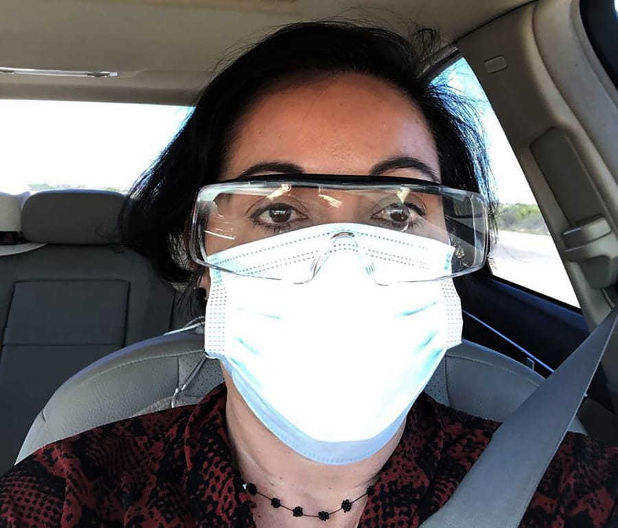 This March 23, 2020 photo provided by Margarita Silva shows her wearing her husband&#039;s land surveyor goggles, a mask she borrowed from a friend and medical gloves she got from a hardware store outside the La Palma Detention Center in Eloy, Ariz. Attorneys and judges in U.S. immigration courts are trying to protect themselves from the coronavirus with borrowed masks and hand sanitizer. The Trump administration has delayed hearings for immigrants who aren&#039;t in detention but is moving forward for those who are.