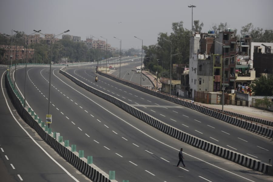 A man crosses an empty expressway during a complete lockdown amid growing concerns of coronavirus in New Delhi, India, Tuesday, March 24, 2020. Authorities have gradually started to shutdown much of the country of 1.3 billion people to contain the outbreak. For most people, the new coronavirus causes only mild or moderate symptoms. For some it can cause more severe illness.