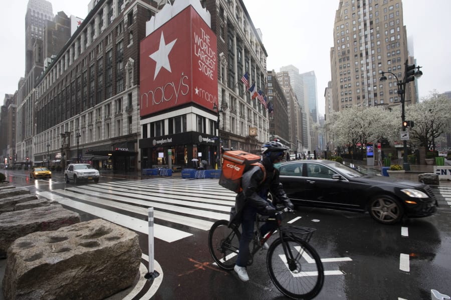 A cyclist passes Macy&#039;s in Herald Square, Monday, March 23, 2020, in New York. Macy&#039;s stores nationwide are closed due to the coronavirus.