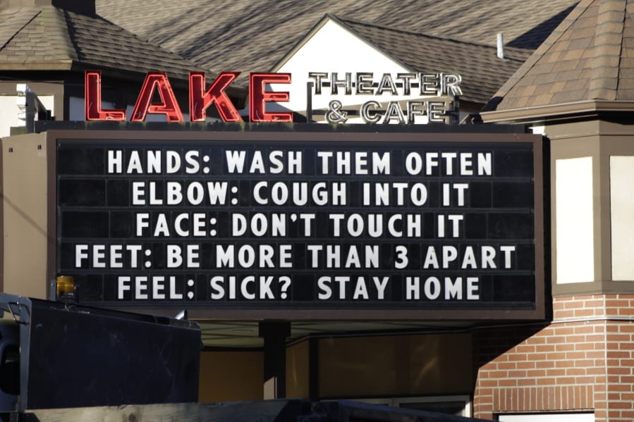 A marquee outside the Lake Theater &amp; Cafe in Lake Oswego, Ore., offers advice on how not to spread germs Tuesday, March 17, 2020. Oregon Gov. Kate Brown on Monday banned on-site consumption at bars and restaurants around the state for at least four weeks in a bid to slow the spread of the new coronavirus and said gatherings will be limited to 25 people or fewer.