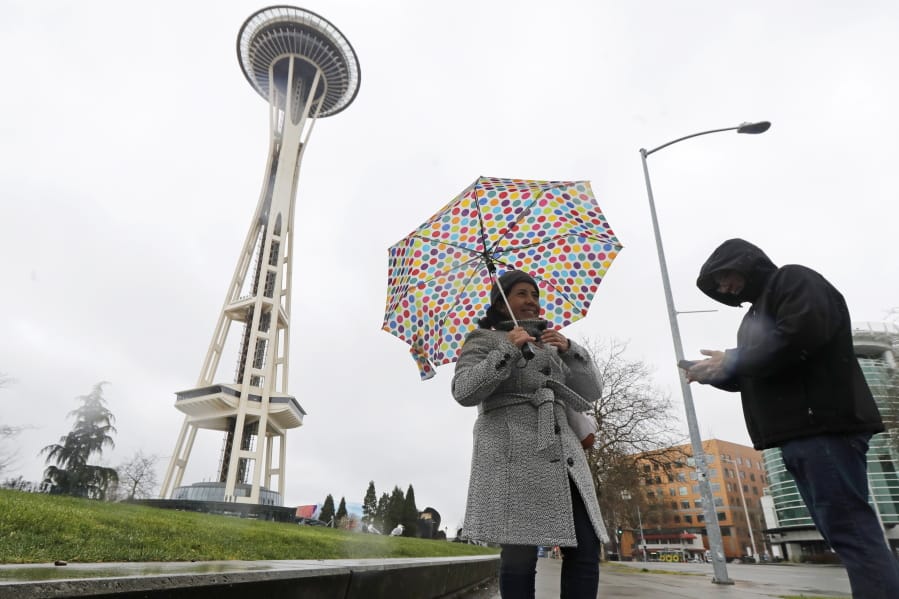 Aida Cruz, left, and Jose Chavez, take photos at the Space Needle, Friday, March 13, 2020, in Seattle. The two were visiting from San Antonio, Texas and had planned to take the elevator up the Needle for a view of the city, but they discovered that the iconic landmark and tourist attraction had closed Friday and will remain so through the end of March due to the outbreak of the COVID-19 coronavirus in Washington state.  The vast majority of people recover from the new coronavirus. According to the World Health Organization, most people recover in about two to six weeks, depending on the severity of the illness. (AP Photo/Ted S.