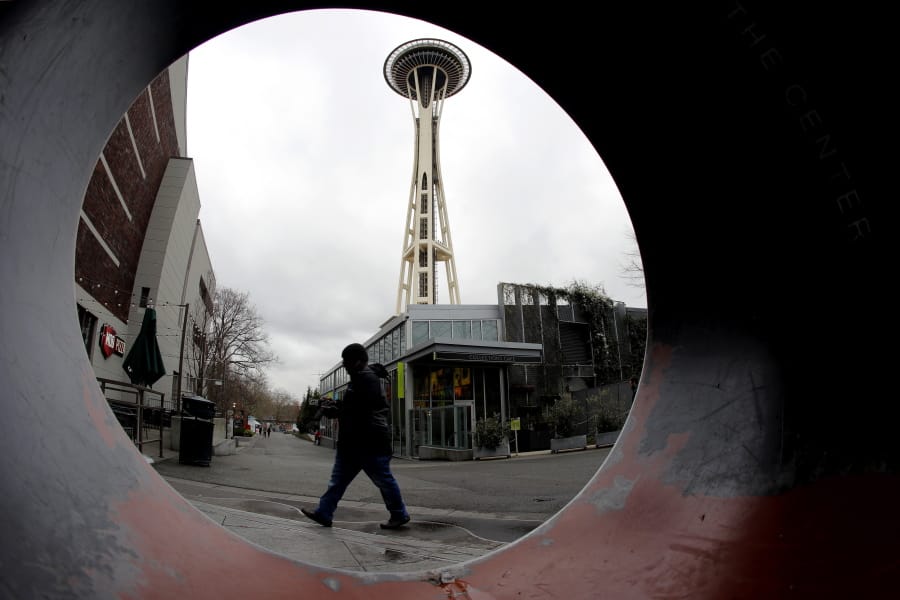 The Space Needle is seen through the round opening of a sculpture at the Seattle Center in Seattle.
