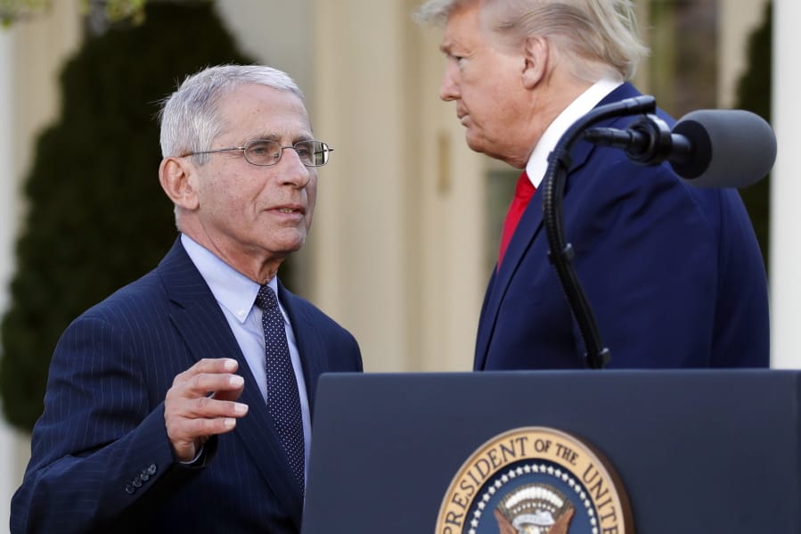 Dr. Anthony Fauci, director of the National Institute of Allergy and Infectious Diseases, takes the podium to speaks about the coronavirus in the Rose Garden of the White House, Monday, March 30, 2020, in Washington, as President Donald Trump listens.