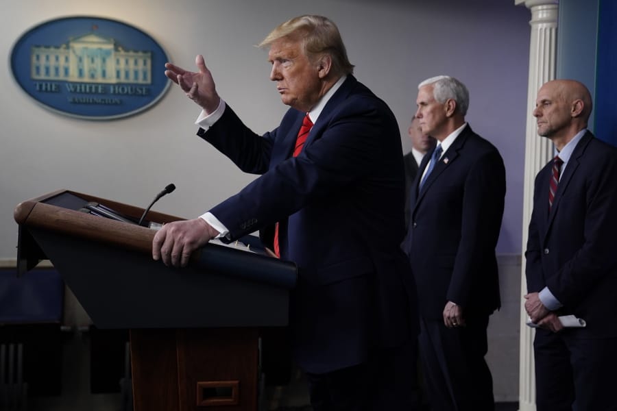 President Donald Trump speaks during press briefing with the coronavirus task force, at the White House, Thursday, March 19, 2020, in Washington. Food and Drug Administration Commissioner Dr. Stephen Hahn, right, and Vice President Mike Pence listen.