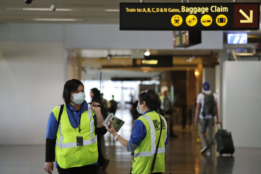A pair of workers at Seattle-Tacoma International Airport wear masks Tuesday, March 3, 2020, in SeaTac, Wash. Six of the 18 Western Washington residents with the coronavirus have died as health officials rush to test more suspected cases and communities brace for spread of the disease. All confirmed cases of the virus in Washington are in Snohomish and King counties.