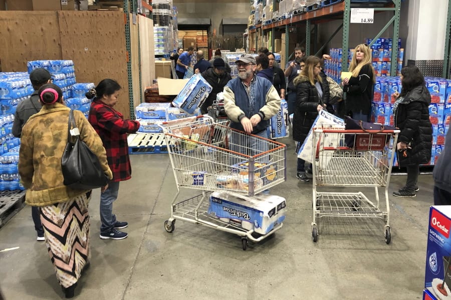 Shoppers wait their turn to pick up toilet paper that had just arrived at a Costco store in Tacoma on March 7. Within minutes, several pallets of toilet paper and paper towels were sold out as people continue to stock up on necessities due to fear of the COVID-19 coronavirus. Similar scenes have occurred at other Costco locations, including in Vancouver. (Ted S.