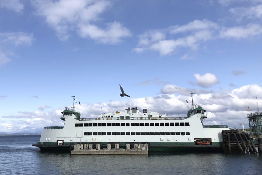 In this photo taken Sunday, March 29, 2020, a Washington state ferry docks at the Point Defiance Ferry Terminal in Tacoma, Wash., on the first day of a new reduced sailing schedule as part of the state&#039;s response to the new coronavirus, including cutting trips on the Seattle/Bainbridge and Seattle/Bremerton routes by about half. (AP Photo/Ted S.