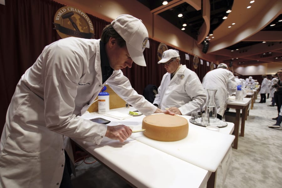 Judge Douwe Dijkstra pulls out a piece of Appenzeller cheese at the biennial World Championship Cheese Contest, Tuesday, March 3, 2020, at the Monona Terrace Convention Center in Madison, Wis. It&#039;s the largest technical cheese, butter and yogurt competition in the world. This year the competition had a record 3,667 entries from 26 nations.