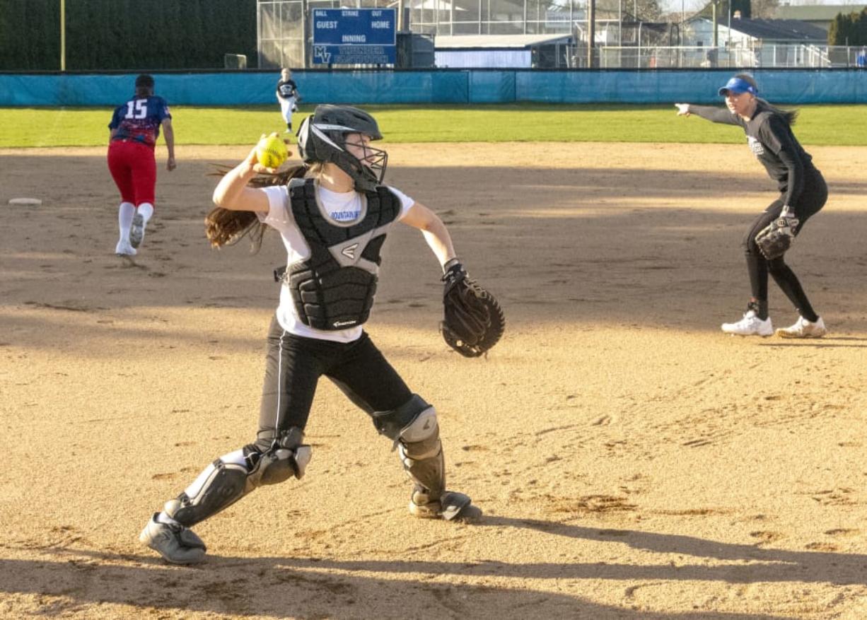 Mountain View catcher Kinsey Martin fields a bunt and fires to first base as Sydney Brown calls out in the background during a practice on March 11.