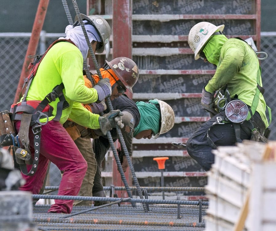 Construction workers labor at the construction site off South Dixie Highway and SW 37th Avenue in Coral Gables, Fla., on March 31, 2020.