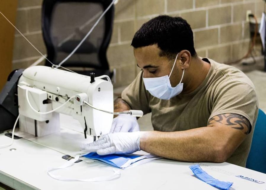 A parachute rigger with 1st Special Forces Group (Airborne), Group Support Battalion, sews surgical masks for medical patients at Joint Base Lewis-McChord. (Sgt. Joe Parrish/U.S.