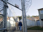 An inmate and guard walk through a gate at Larch Corrections Center in December 2009.