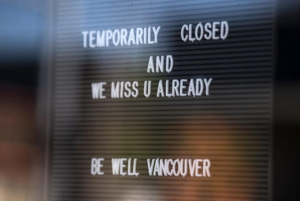A note to customers is written in the window of a salon in Vancouver.