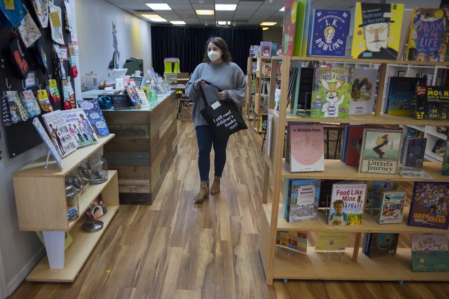 Ruthie Prasil, owner of Dickens Children&#039;s Books, prepares to drop off an order to a customer outside her store in Uptown Village on Thursday.