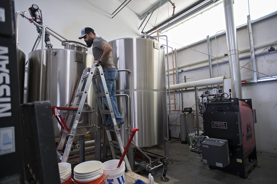 Darin Kyle of Quartz Mountain Distillery keeps an eye on the mash run in preparation for making hand sanitizer to help during the COVID-19 pandemic at his Walnut Grove business.
