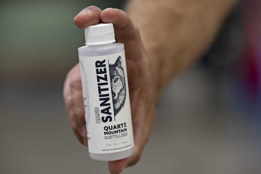 Darin Kyle of Quartz Mountain Distillery displays a bottle of hand sanitizer at his Walnut Grove business in April 2020.