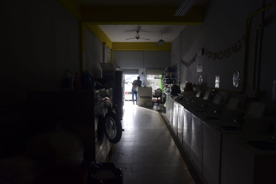 Laundromat owner Jesus Vazquez pauses before closing his shop to comply with the government&#039;s curfew aimed at curbing the spread of the new coronavirus, which is shuttering all non-essential businesses for two weeks in San Juan, Puerto Rico, Friday, March 20, 2020.