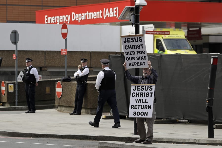 A man holds up a sign outside St Thomas&#039; Hospital in central London, where Prime Minister Boris Johnson remains in intensive care as his coronavirus symptoms persist, Wednesday, April 8, 2020. Johnson has spent his second night in hospital intensive care. The new coronavirus causes mild or moderate symptoms for most people, but for some, especially older adults and people with existing health problems, it can cause more severe illness or death.