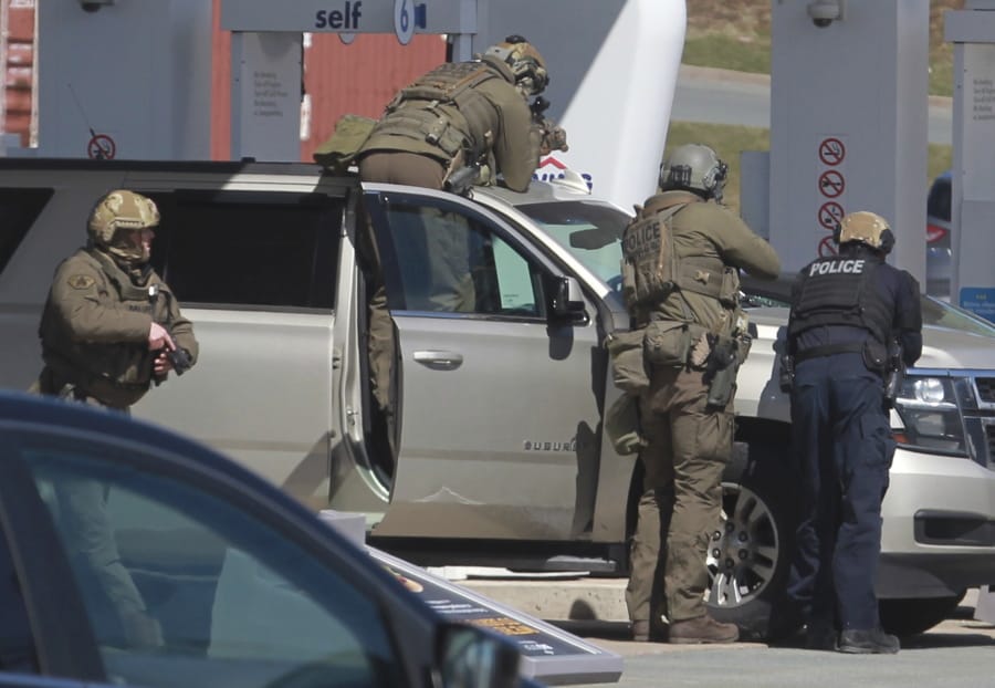 Royal Canadian Mounted Police officers surround a suspect at a gas station in Enfield, Nova Scotia, Sunday April 19, 2020. Canadian police say multiple people are dead plus the suspect after a shooting rampage across the province of Nova Scotia. It was the deadliest shooting in Canada in 30 years.