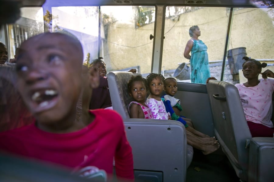 FILE - In this Feb. 14, 2020 file photo, orphans sit inside a social services bus after police removed them from a children&#039;s home run by the Orphanage of the Church of Bible Understanding (COBU), following a fire at one of the organization&#039;s other homes in Kenscoff, on the outskirts of Port-au-Prince, Haiti. The fire on Feb. 13 killed 13 children and two adult caretakers described  as disabled by authorities and the church&#039;s lawyer.