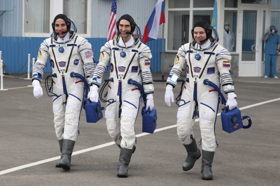 In this handout photo released by Roscosmos Space Agency Press Service U.S. astronaut Chris Cassidy, left, Russian cosmonauts Anatoly Ivanishin, centre, and Ivan Vagner, members of the main crew of the expedition to the International Space Station (ISS), walk prior the launch of Soyuz MS-16 space ship at the Russian leased Baikonur cosmodrome, Kazakhstan, Thursday, April 9, 2020.