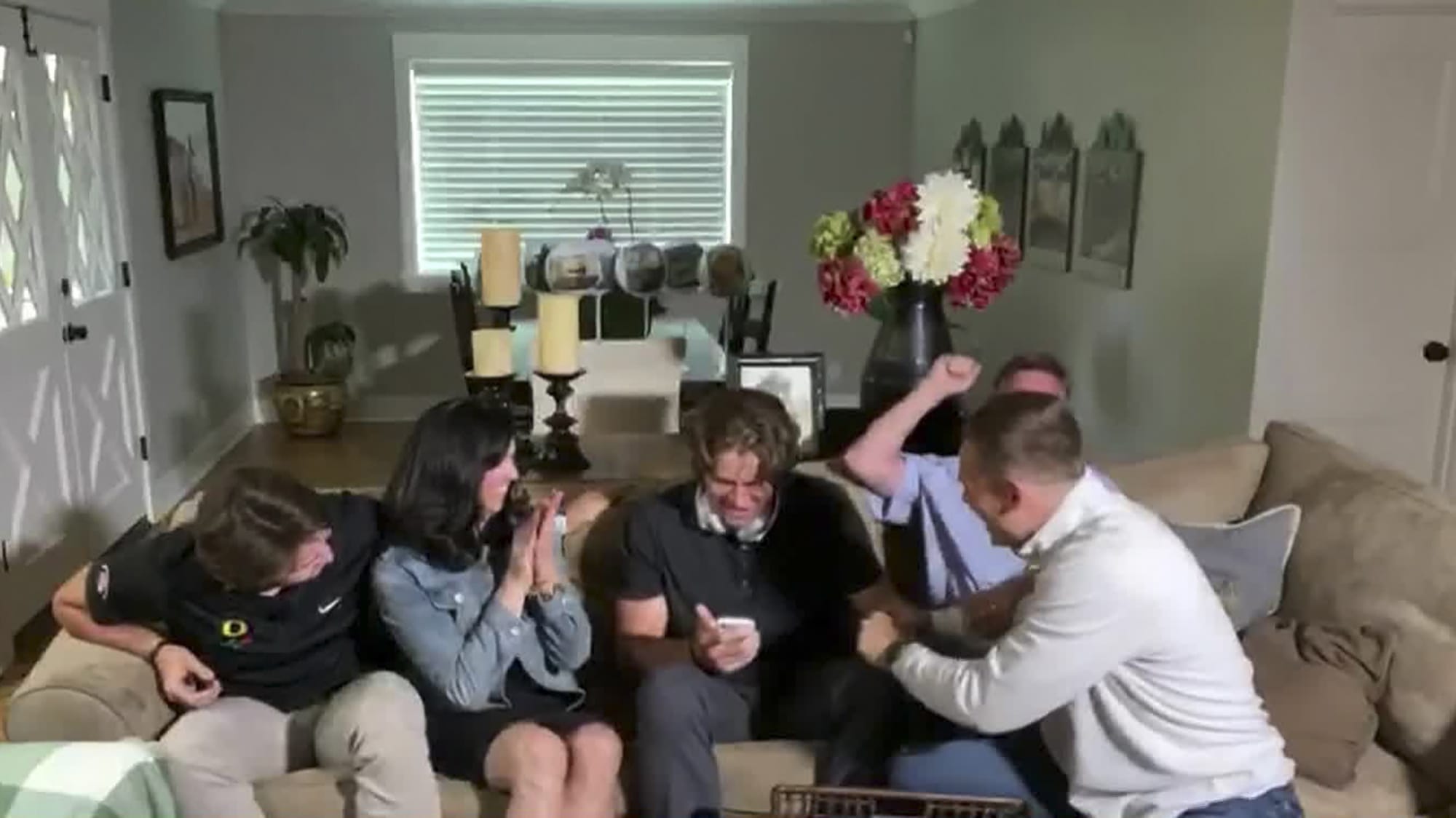In this still image from video provided by the NFL, Justin Herbert holds his phone during the NFL football draft Thursday, April 23, 2020. The Los Angeles Chargers selected Herbert with the sixth pick.
