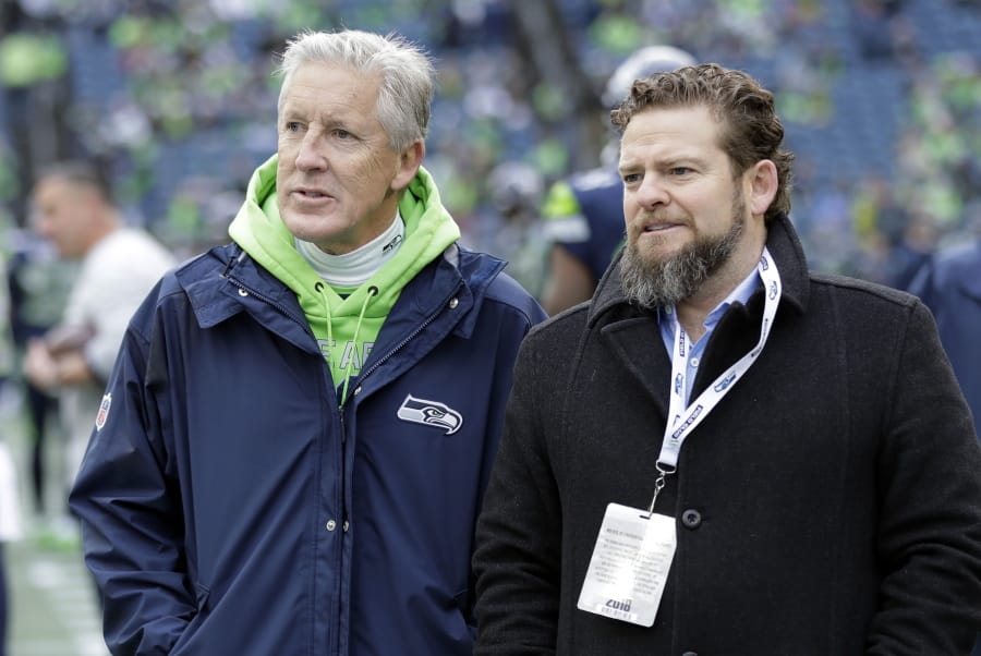 FILE - In this Dec. 30, 2018, file photo, Seattle Seahawks coach Pete Carroll, left, talks with general manager John Schneider before  the team&#039;s NFL football game against the Arizona Cardinals in Seattle. There is a clear and obvious need for the Seahawks to address along the defensive line and it happens to be one of the deeper positions of talent in the entire draft. That may be far too simplistic and straightforward for Schneider and Carroll. Schneider is always good for a few surprises in the draft, and more than a couple of trades.