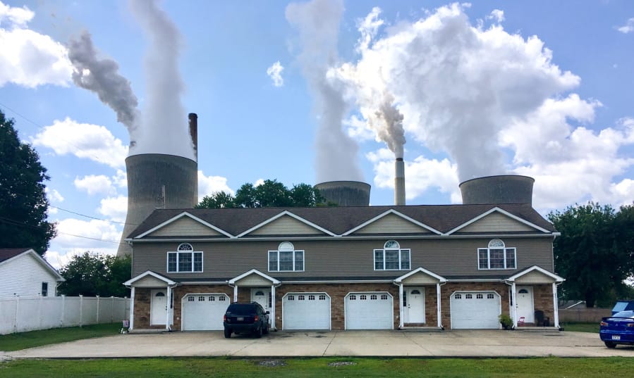 FILE - In this Aug. 23, 2018, file photo, a coal-fired plant in Winfield, W.Va, is seen from an apartment complex in the town of Poca across the Kanawha River. The Trump administration is gutting an Obama-era rule that compelled coal plants to cut back emissions of mercury and other human health hazards, limiting future regulation of air pollutants by petroleum and coal plants.