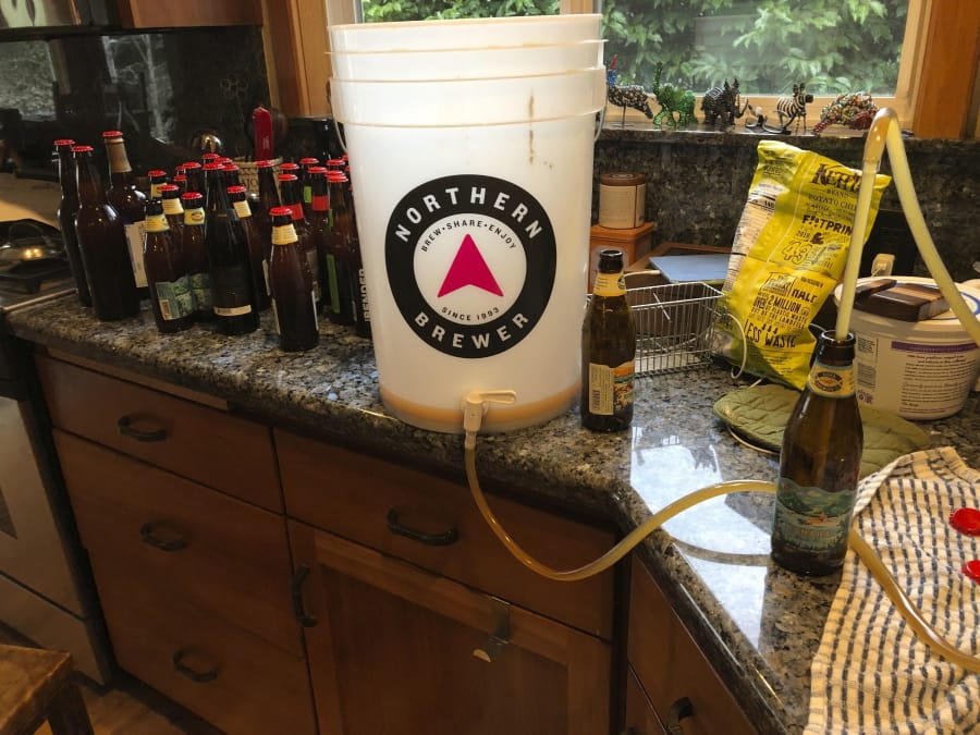 This March 28, 2020 photo shows home-brewed beer being bottled in Salem, Ore. Homebrewing provides an escape from dwelling on the COVID-19 pandemic.